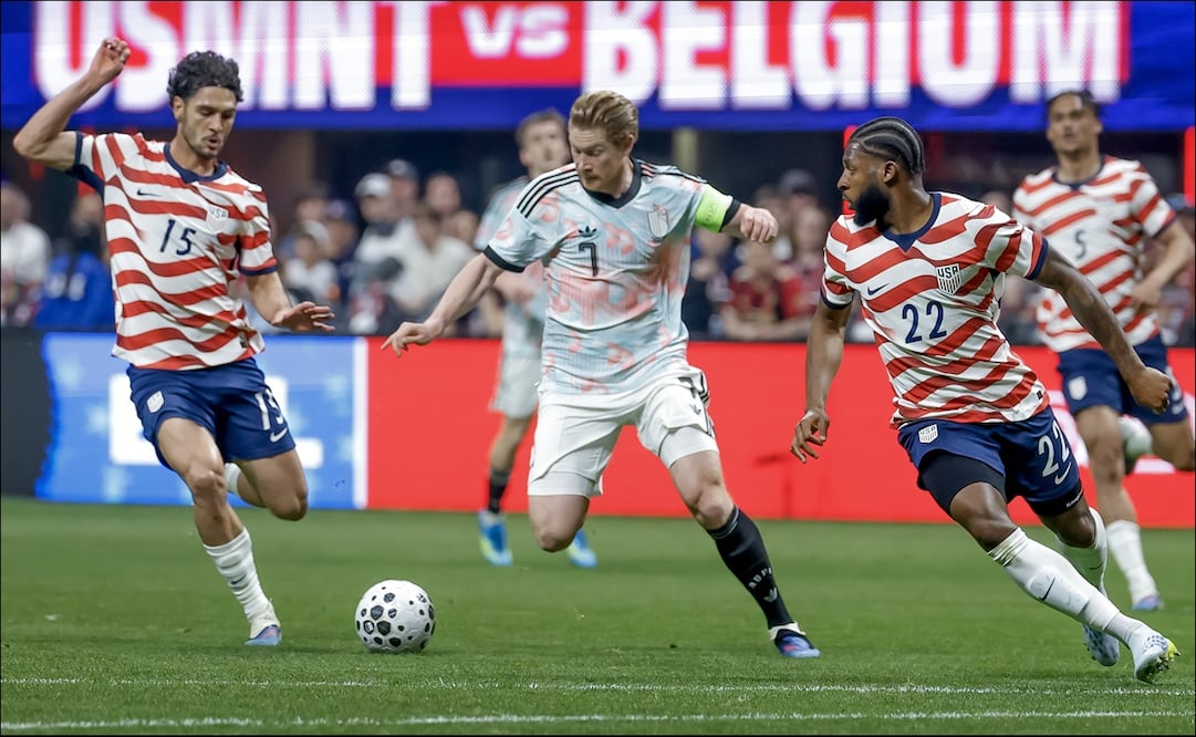 Kevin De Bruyne conduce el balón ante Johnny Cardoso y Mark McKenzie de Estados Unidos. FOTO: EFE