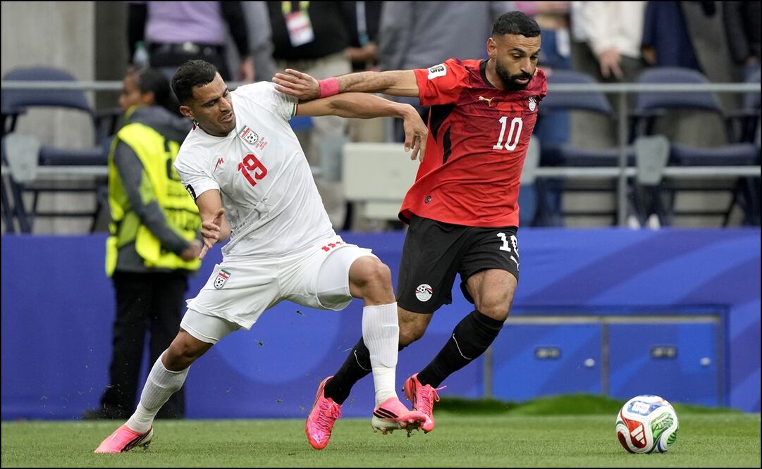 Ali Nemati y Mohamed Salah disputan el balón en el partido entre las selecciones de Irán y Egipto. FOTO: EFE