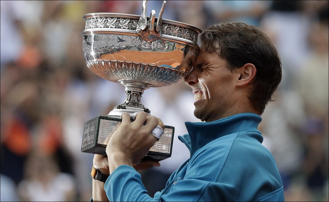 Rafael Nadal sostiene su trofeo al celebrar su triunfo en la Final varonil de Roland Garros, en 2018. AP