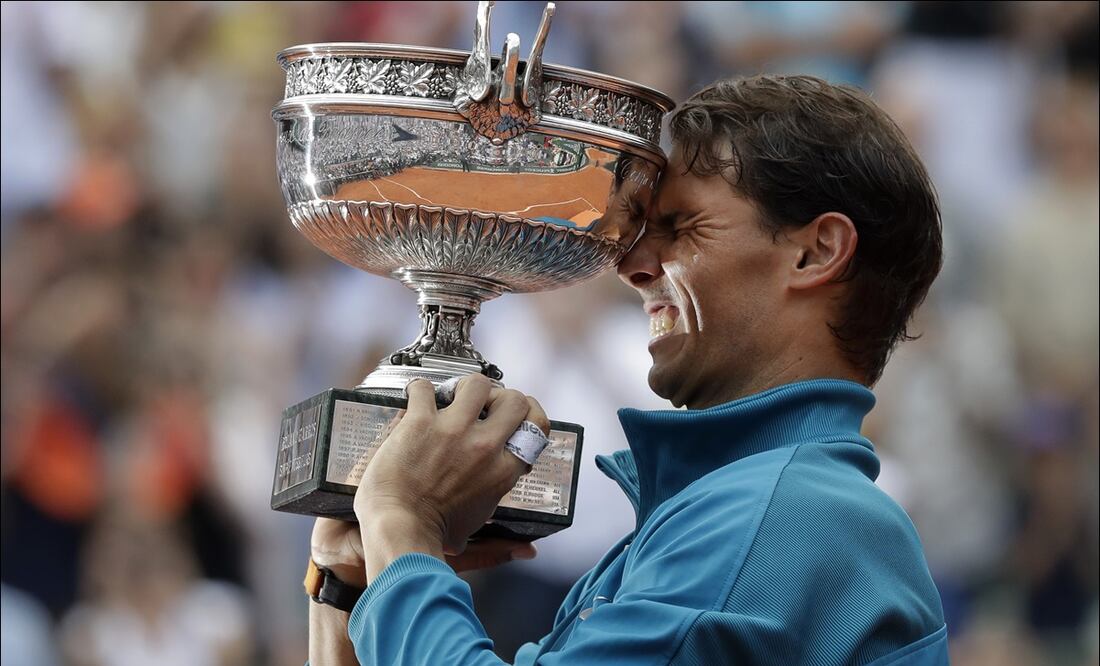 Rafael Nadal sostiene su trofeo al celebrar su triunfo en la Final varonil de Roland Garros, en 2018. AP
