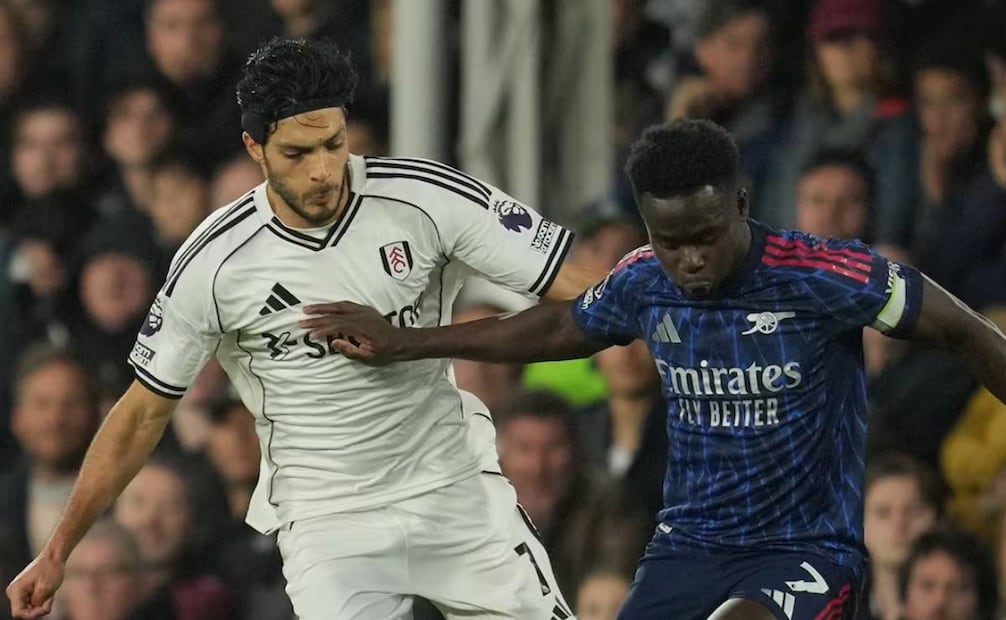 Raúl Jiménez le trata de quitar el balón a Bukayo Saka