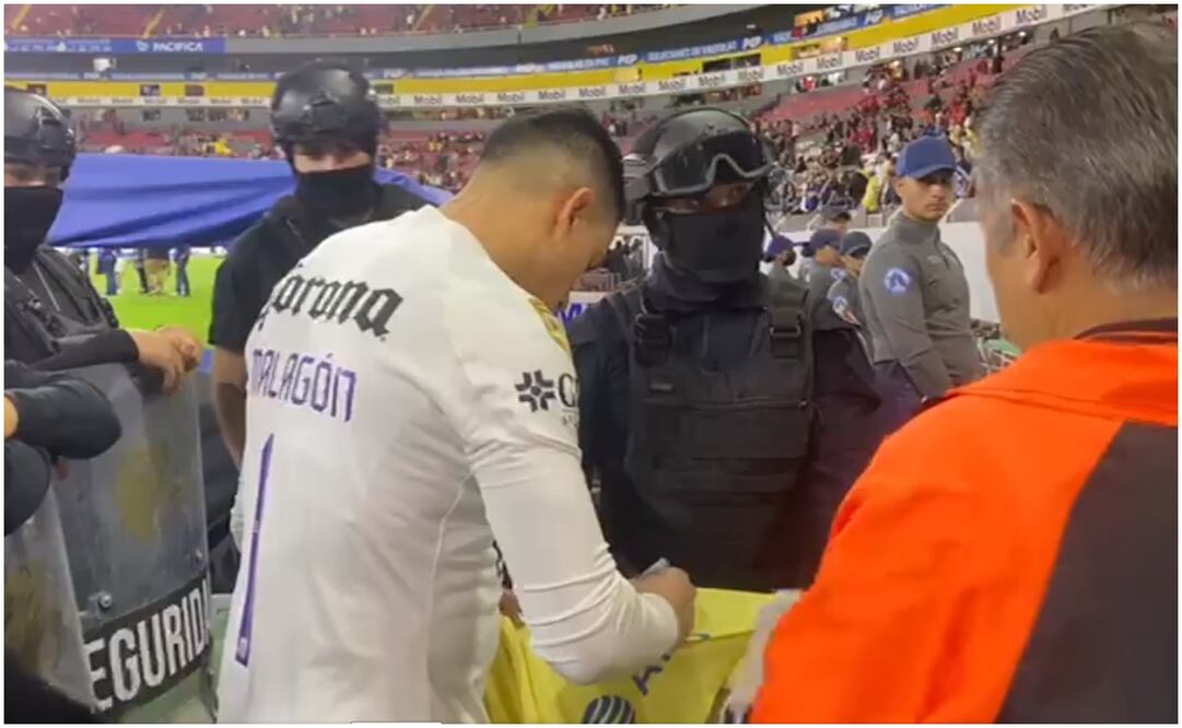 Luis Ángel Malagón firmando una playera para un policía / FOTO: Captura