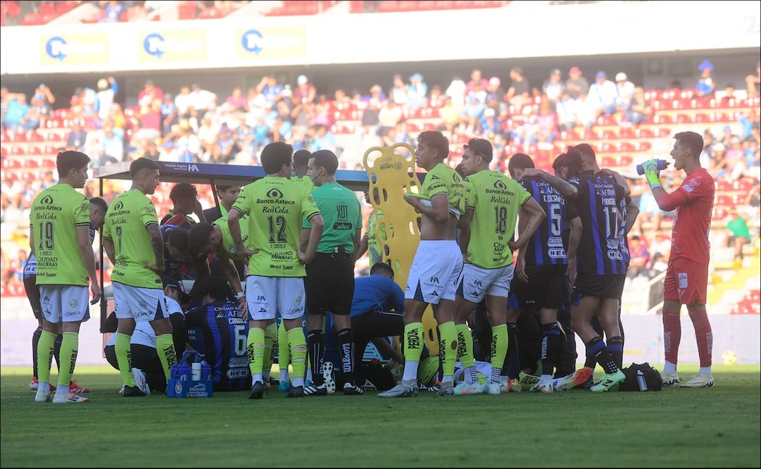 Jugadores de Querétaro y Puebla rodean a Emiliano Gómez y José Canale tras su fuerte choque. FOTO Imago7