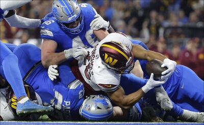 Jeremy McNichols (26) corredor de los Commanders acarrea el ovoide para conseguir un touchdown ante los Lions.  FOTO: AP