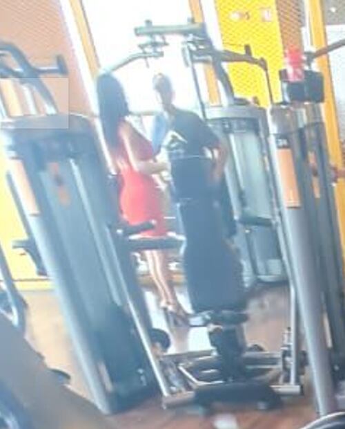 Lalo Trelles charla en el gimnasio con su esposa Lorena Cid, quien porta un vestido rojo y zapatillas. FOTO: De10sports