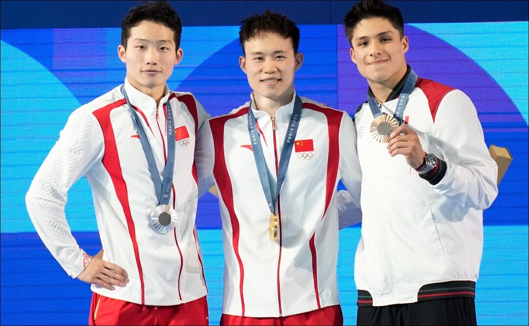 Osmar Olvera presume su prese a de bronce en el podio junto a los competidores chinos. FOTO: AP