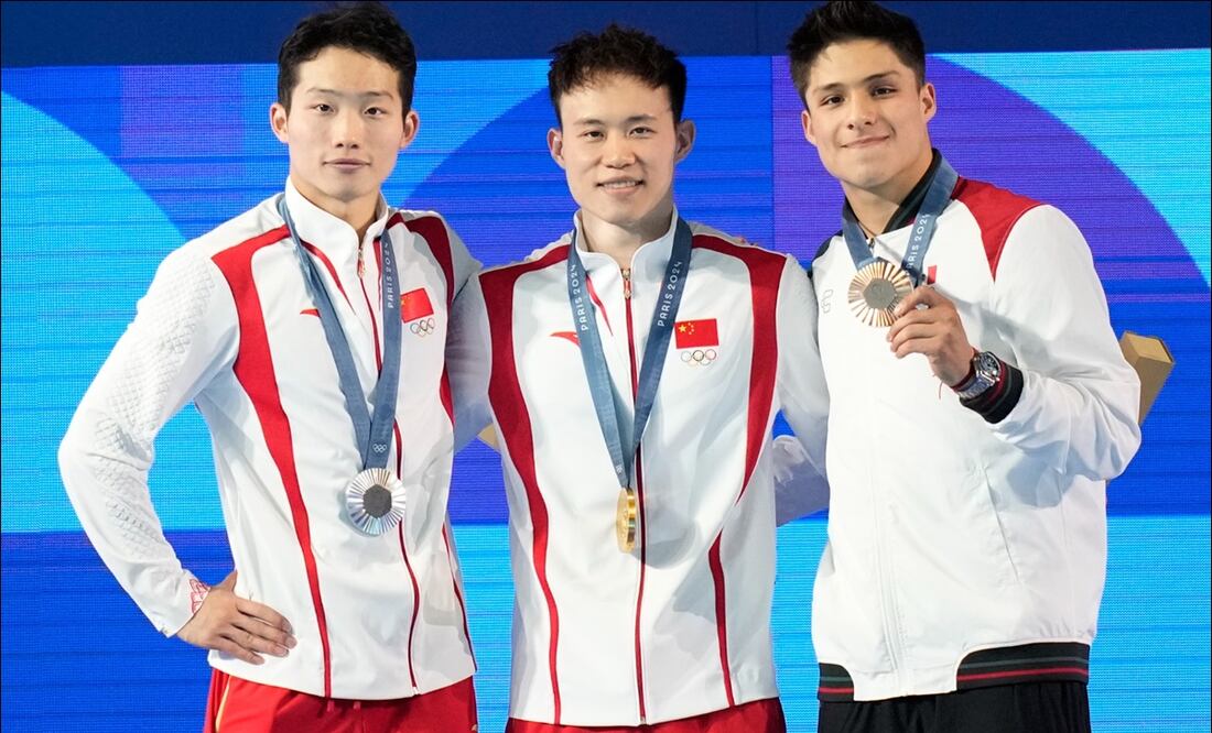 Osmar Olvera presume su prese a de bronce en el podio junto a los competidores chinos. FOTO: AP