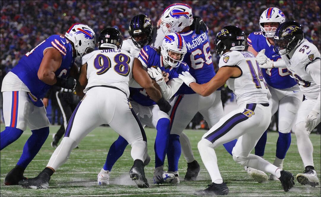 Josh Allen (17), de los Buffalo Bills, corre con el balón en contra de Travis Jones (98) y Kyle Hamilton (14), de los Baltimore Ravens, en el segundo cuarto de su juego de la Ronda Divisional. FOTO: AFP