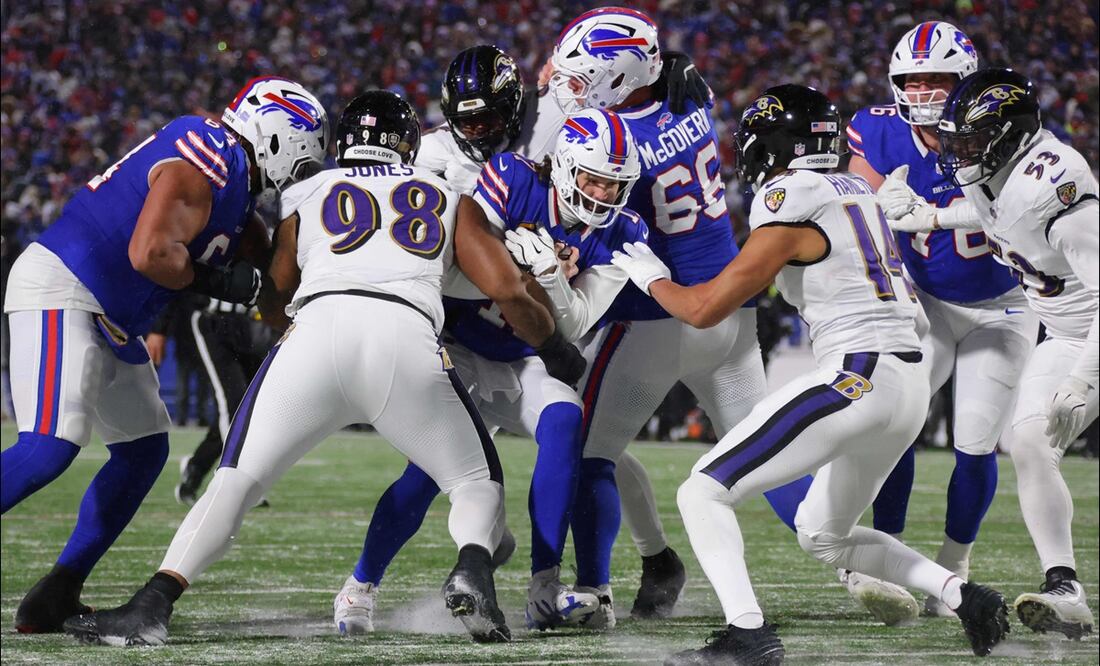 Josh Allen (17), de los Buffalo Bills, corre con el balón en contra de Travis Jones (98) y Kyle Hamilton (14), de los Baltimore Ravens, en el segundo cuarto de su juego de la Ronda Divisional. FOTO: AFP